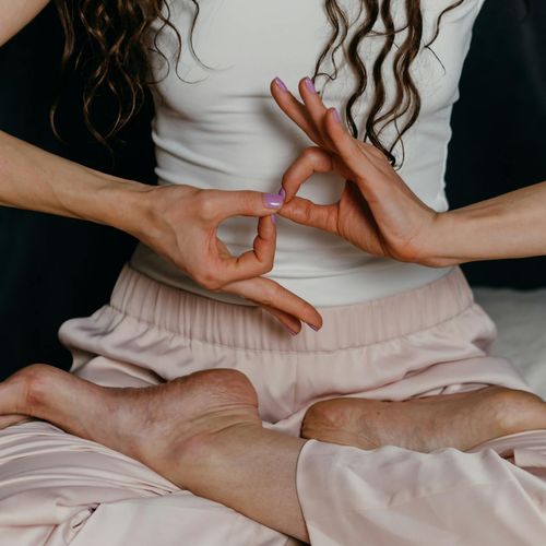Close-up of a woman's hands in a yoga mudra gesture.